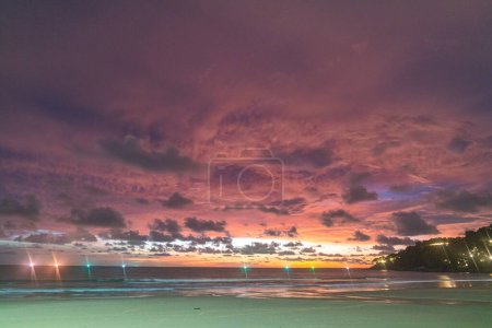 Foto de Escena romántica cielo rosa en la puesta de sol sobre el océano.. Puesta de sol con rayos de luz de color rojo brillante y otros efectos atmosféricos.. nube de colores en el cielo brillante. Cielo textura abstracta naturaleza fondo.. - Imagen libre de derechos
