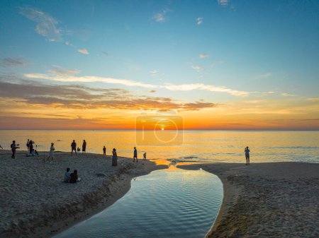 Photo for Aerial view of the winding canal on the sandy beach.Tourists watch the sun set beside a small canal on a sandy beach.beautiful sky reflection in the canal.bubble waves and clear sand landscape. - Royalty Free Image