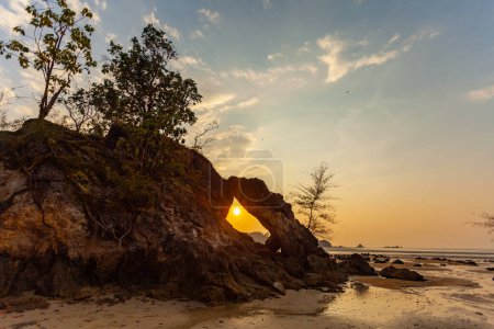 Foto de Increíble El sol de la noche brilló a través del gran agujero de roca y brilló maravillosamente. - Imagen libre de derechos