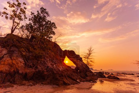 Foto de Increíble El sol de la noche brilló a través del gran agujero de roca y brilló maravillosamente. - Imagen libre de derechos
