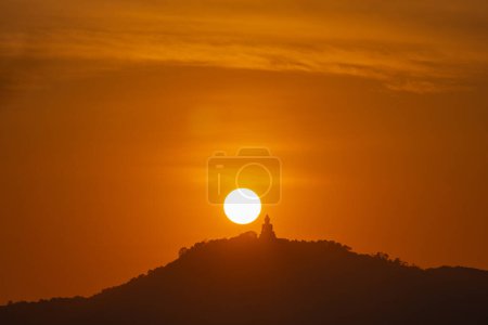 Téléchargez les photos : Le soleil tourne dans le ciel rouge au-dessus de Phuket Big Buddha - en image libre de droit