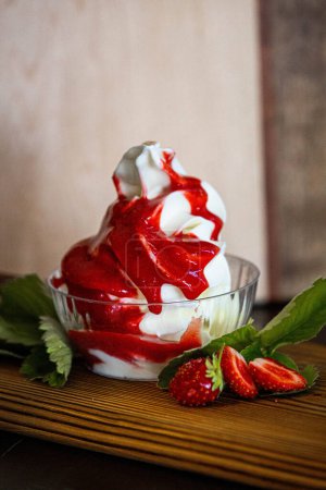 Téléchargez les photos : Crème glacée avec sauce aux fraises et saupoudrer tout autour. - en image libre de droit