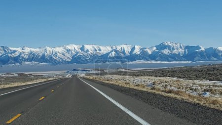 Photo for This photo captures the beauty and solitude of Route 50, the loneliest highway in America. The road stretches across the Nevada desert, surrounded by stunning mountains and clouds. - Royalty Free Image