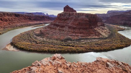 Photo for This stunning photo captures the dramatic beauty of Gooseneck Overlook in Moab, Utah. The winding Colorado River cuts through the red rock canyon, creating a breathtaking landscape that is a must-see destination for nature lovers and adventurers. - Royalty Free Image