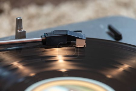 Téléchargez les photos : Gros plan d'un disque vinyle tournant sur une plaque tournante avec des reflets lumineux accentuant la surface du disque. - en image libre de droit