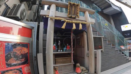 Téléchargez les photos : Un petit sanctuaire à Ginza, Tokyo, Japon. Le dieu des terres de luxe avec le prix le plus élevé au Japon. Renard, tablier rouge, petit sanctuaireUn petit sanctuaire à Ginza, Tokyo, Japon. Kumagaya Inari - en image libre de droit