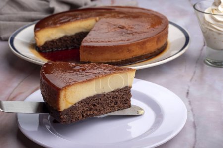 süßes Schokoladendessert mit Schokoladenkuchen und Leche Flan oder umgedrehter Kuchen mit Sahne und Schokoriegel