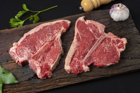 Téléchargez les photos : Viande de bœuf différentes coupes côtes rôties et steaks sur planche de bois et assiettes de fer assaisonnements et ingrédients - en image libre de droit