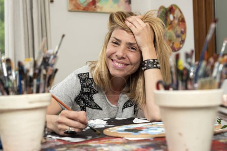 Foto de Joven artista en su estudio de arte y pintura feliz por su estilo de vida optimista creando imágenes y arte - Imagen libre de derechos