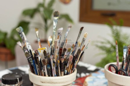 Foto de Pinceles de arte y pintura dentro de un soporte de pincel en la mesa de trabajo de un pintor artístico - Imagen libre de derechos