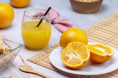 Téléchargez les photos : Petit déjeuner ou collation avec jus d'orange pressé naturel aux fruits frais céréales sur table blanche - en image libre de droit
