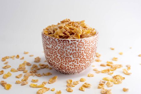 Téléchargez les photos : Tasse en céramique de différentes couleurs avec des céréales de maïs saines et nutritives avec un fond blanc - en image libre de droit