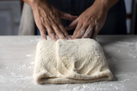 Téléchargez les photos : Mains de boulangers femmes et hommes faisant la pâte pour les croissants étape par étape, pétrissant et assemblant les croissants prêts à cuire - en image libre de droit