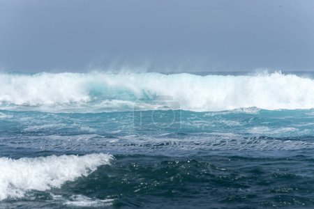Téléchargez les photos : Paysage de plage avec la mer et les vagues et les falaises des côtes des îles Galapagos dans l'océan Pacifique avec des eaux bleues et vertes et des roches volcaniques - en image libre de droit