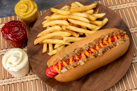 Téléchargez les photos : Hot dog aux grandes saucisses différentes variétés avec vinaigrettes mayonnaise moutarde ketchup oignon bacon fromage concombres et frites - en image libre de droit