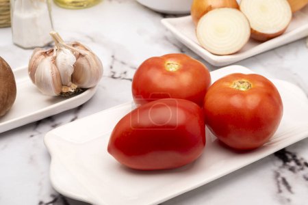 Téléchargez les photos : Mise en place sur la table avec assortiment de légumes en vaisselle blanche avec vinaigre d'huile de poivre et sel pour salade et repas végétariens et végétaliens - en image libre de droit