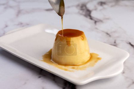 Téléchargez les photos : Flan maison ou fromage vénézuélien au caramel entier et en portions individuelles ou grandes sur vaisselle blanche - en image libre de droit