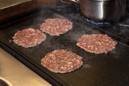 Kochen, Montage und Herstellung von hausgemachten Hamburgern mit Hackfleisch und Chefkoch macht die Medaillons Schritt für Schritt, die Gesamtmontage aller Zutaten 
