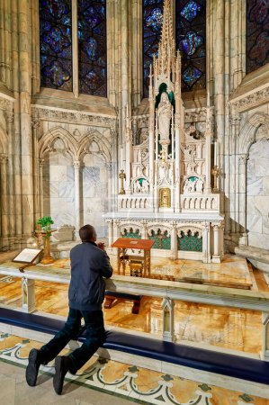 Photo for New York. Manhattan. United States. St. Patrick's cathedral. A faithful prays in a chapel - Date: 23 - 04 - 2022 - Royalty Free Image