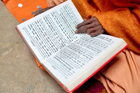 Téléchargez les photos : L'Inde. Varanasi Benares Uttar Pradesh. Un homme lisant les textes sacrés de l'hindouisme et priant - Date : 03 - 01 - 2023 - en image libre de droit