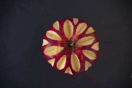 Téléchargez les photos : Pomme rouge vif sur fond noir isolé. La pomme est sculptée. Photo de haute qualité - en image libre de droit
