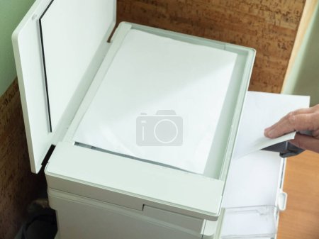 Foto de Impresora copiadora, un hombre hace una copia de un documento de hoja en la impresora - Imagen libre de derechos