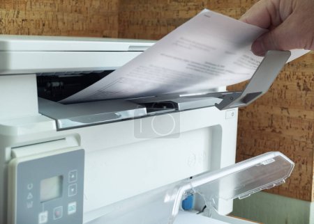 Foto de Impresora copiadora, un hombre hace una copia de un documento de hoja en la impresora - Imagen libre de derechos