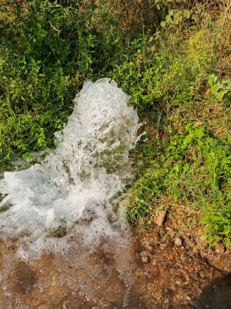 Water coming out of pipe in the field.
