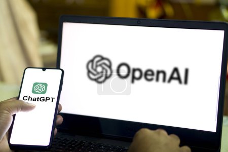 Foto de Logo de ChatGPT visto en la pantalla de teléfonos inteligentes y portátiles con el logotipo borroso de la compañía OpenAI. Dhaka, Bangladesh - 07 de febrero de 2024: - Imagen libre de derechos