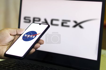 Téléchargez les photos : Logo NASA sur l'écran d'un Smartphone avec un fond flou du logo SpaceX vu affiché.Bangladesh- 15 février 2024. - en image libre de droit