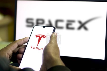 Téléchargez les photos : Logo Tesla sur smartphone Logo SpaceX affiché background.Bangladesh- 15 février 2024. - en image libre de droit