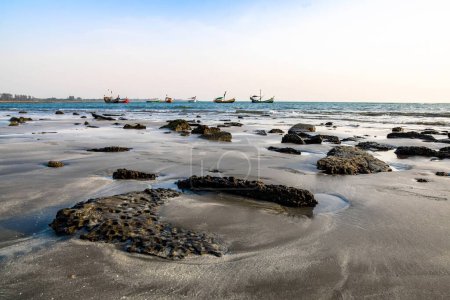 Photo for Beautiful view of the sea. Stunning rocky beach at Saint Martin Island, Bangladesh. The sky is a beautiful blue with white clouds. peaceful moment at this coastal location where nature meets human activity in perfect harmony. - Royalty Free Image