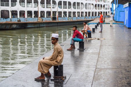 Téléchargez les photos : Les gens sont assis près de la rivière dans le port Sadarghat, Dacca. - en image libre de droit