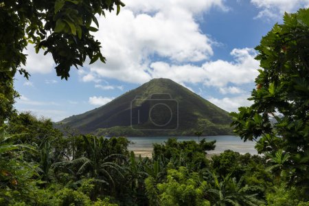 Téléchargez les photos : Les îles pittoresques de Banda et le volcan Bandaneira encadrés par les arbres tropicaux verts vue de l'île de Banda Besar, Maluku, Indonésie - en image libre de droit