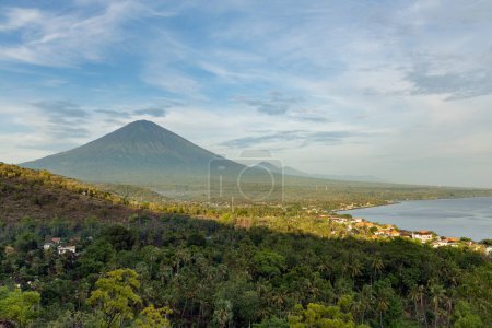 Scenic view of mount Agung volcano and Amed fishing village in Karangasem district, Bali during early morning sunlight