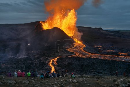 Foto de Grupo de personas observando majestuosa erupción volcánica y flujo de lava en Fagradalsfjall, Geldingadalir, Península de Reykjanes. - Imagen libre de derechos