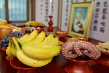 Photo for In a Korean living room, a Charye table is set with an array of offerings such as fruits, beef, and octopus, alongside various savory jeon pancakes, honoring ancestral spirits. - Royalty Free Image