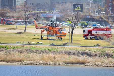 Téléchargez les photos : Les hélicoptères de lutte contre les incendies sont ravitaillés en carburant au parc Taehwa, ce qui témoigne de la préparation rigoureuse des services aériens d'urgence coréens.. - en image libre de droit