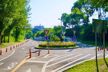 Téléchargez les photos : Séoul, Corée du Sud - 2 juin 2023 : Un rond-point cyclable unique près du Jamsil Railroad Bridge, avec des lignes et des panneaux complexes, avec un cube circulaire médian distinct en son centre. - en image libre de droit