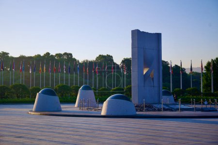 Photo for Seoul, South Korea - June 2, 2023: A striking concrete sculpture in Olympic Park, with a row of flags from competing nations fluttering in the background. - Royalty Free Image