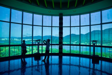 Photo for Hanam City, South Korea - October 1, 2023: Inside the Hanam Union Tower's top deck, visitors are captivated by the stunning view of the river and riverside mountains through the expansive windows. - Royalty Free Image
