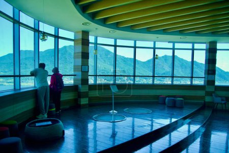 Photo for Hanam City, South Korea - October 1, 2023: Inside the viewing deck of Hanam Union Tower, two people admire the panoramic view of Yebongsan Mountain through the expansive wraparound windows. - Royalty Free Image