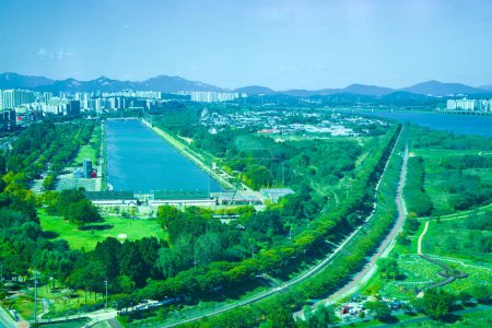 Photo for Hanam City, South Korea - October 1, 2023: A broad aerial perspective from atop Hanam Union Tower, showcasing the Misa Boat Race Park's rectangular lake alongside the riverside bike path by Han River. - Royalty Free Image