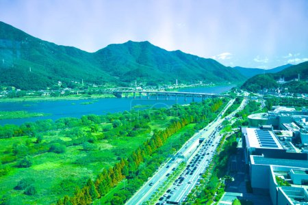 Photo for Hanam City, South Korea - October 1, 2023: A striking view from Hanam Union Tower, capturing Paldang Bridge and the Han River, set against mountains and a clear blue sky. - Royalty Free Image