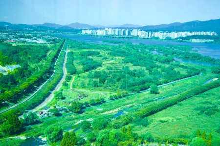 Photo for Hanam City, South Korea - October 1, 2023: Captured from Hanam Union Tower, this wide shot showcases the intertwining bike and walking paths along the green Han River, near Misa Boat Race Park. - Royalty Free Image