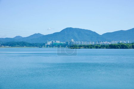 Photo for Guri City, South Korea - September 30, 2023: A sweeping view of the wide Han River from Guri Han River Park, with distant mountains and the cityscape of Hanam visible on the horizon. - Royalty Free Image