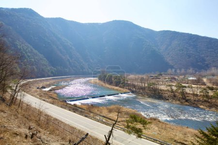 Téléchargez les photos : Mungyeong City, Corée du Sud - 10 février 2021 : Vue de la région de Jinnamgyoban, montrant le fleuve Yeong avec un petit barrage, entouré de hautes montagnes, et une route tissant à travers le paysage. - en image libre de droit