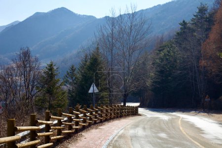 Téléchargez les photos : Comté de Goesan, Corée du Sud - 10 février 2021 : Une route de montagne sinueuse qui monte le col d'Ihwa sous l'imposante montagne Joryeong près du col historique Mungyeong Saejae. - en image libre de droit