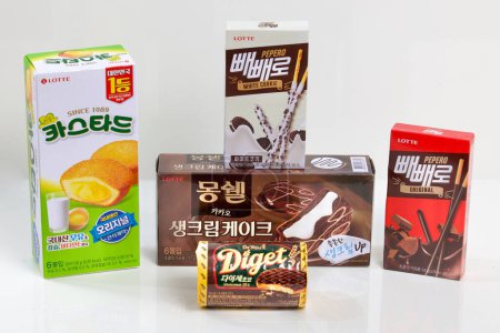 Foto de Ulsan, Corea del Sur - 6 de marzo de 2020: Una deliciosa selección de aperitivos coreanos dulces con pasteles de crema, Pepero, Choco Pies y galletas digestivas, organizados artísticamente sobre un fondo blanco. - Imagen libre de derechos