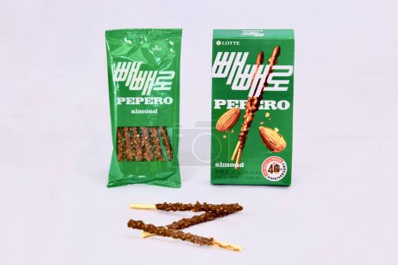Photo for Ulsan, South Korea - January 14, 2024: Almond and Chocolate Pepero, delightful thin cookie sticks with compound chocolate, displayed in front of their inner packaging and green box made by Lotte Confectionery. Pepero is a beloved snack in Korea, know - Royalty Free Image